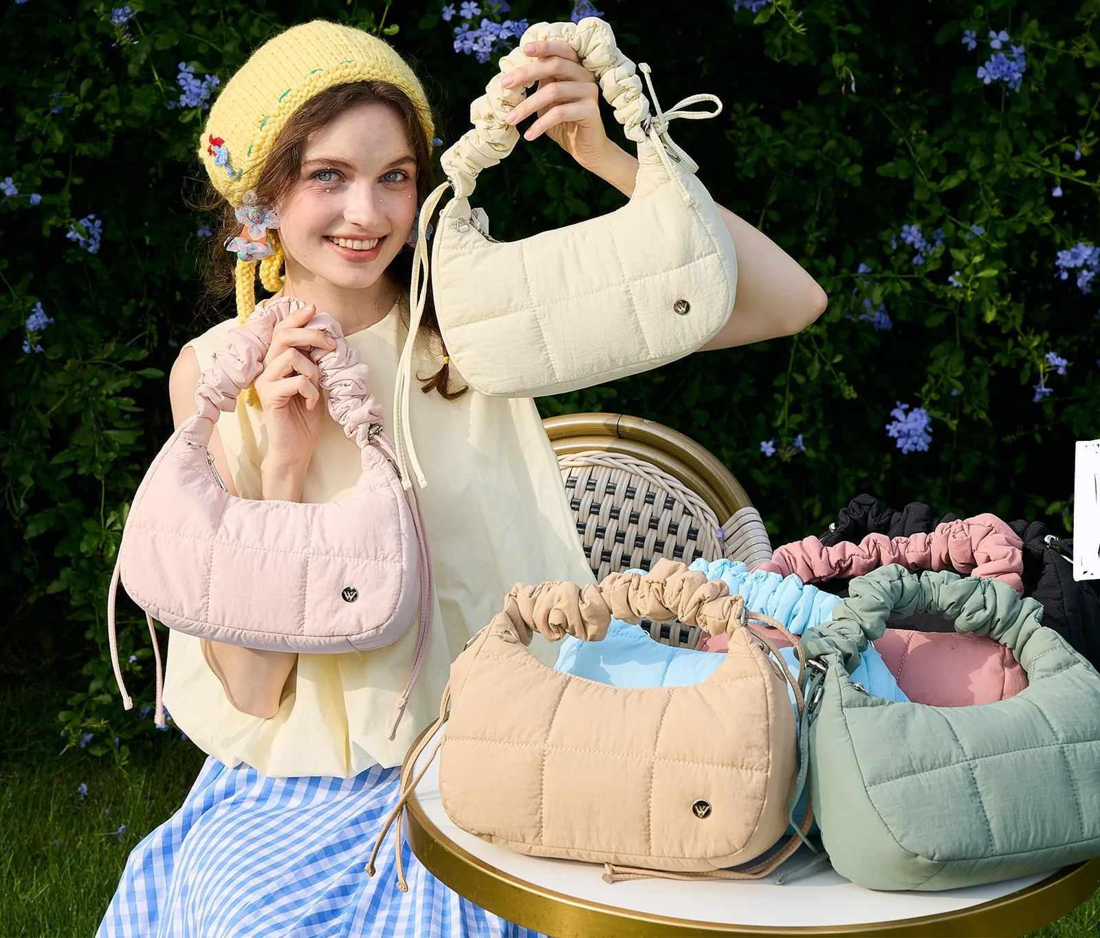 WESTBRONCO puffer bags in cream, blush and sage on a garden table