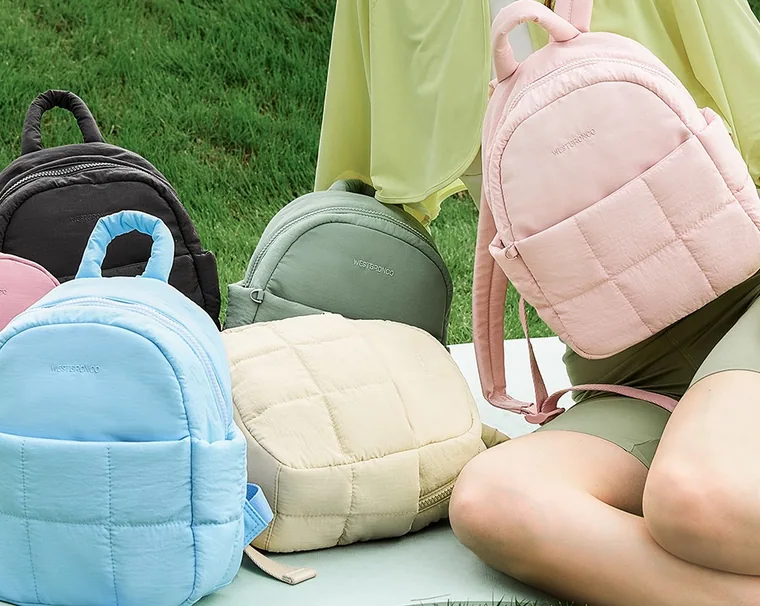 Five quilted mini backpacks on the grass